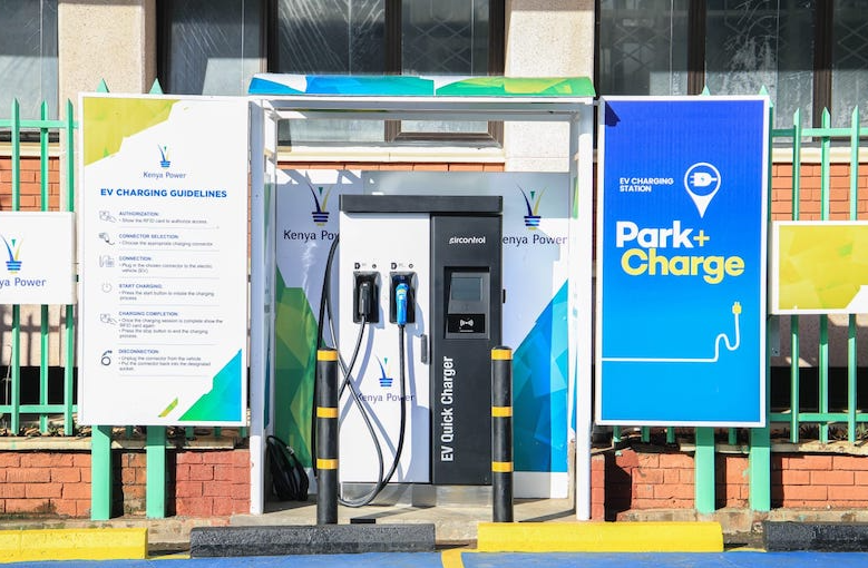 An image of a modern electric vehicle charging station with sleek metallic charging ports and a user-friendly digital interface