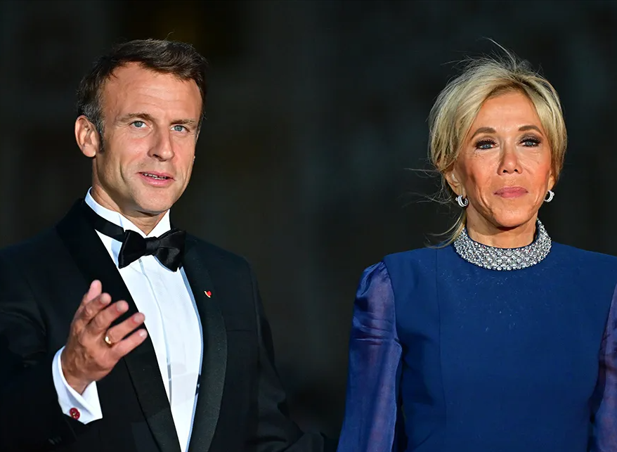 An image of French President Emmanuel Macron and First Lady Brigitte Macron standing side-by-side.